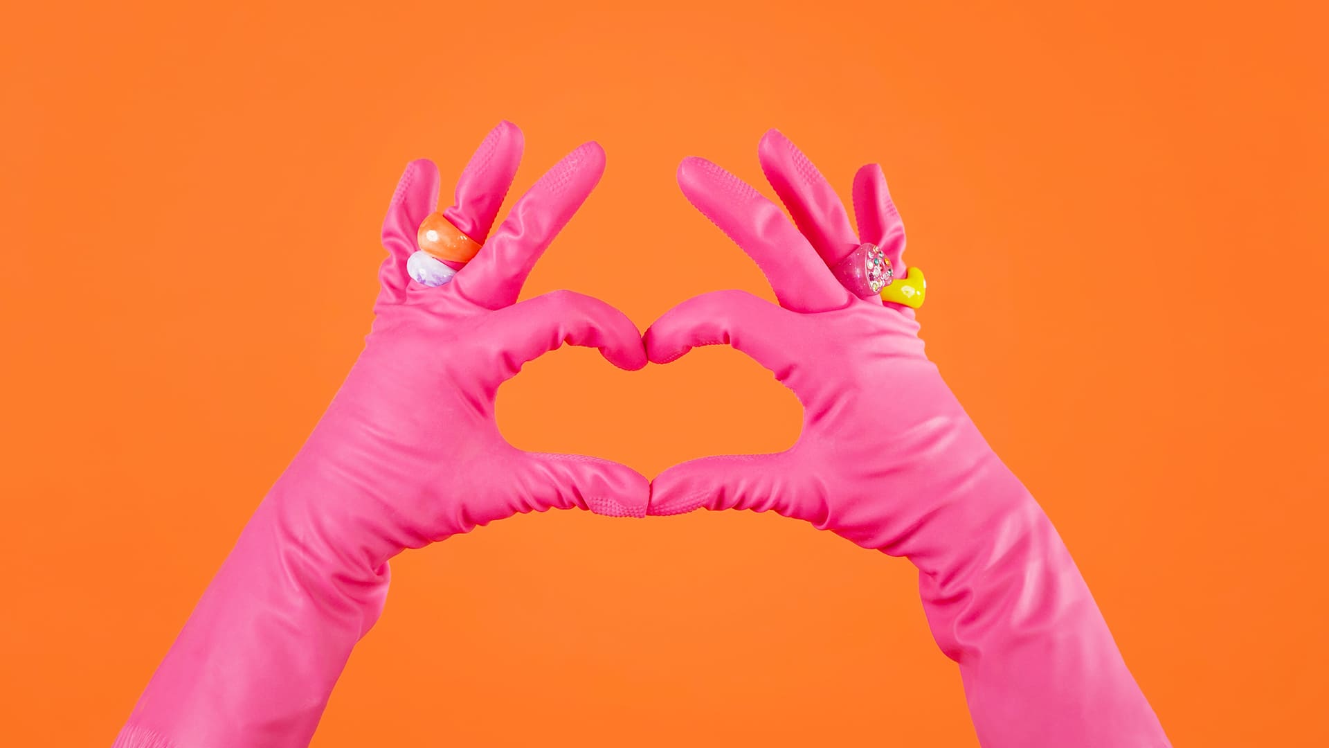 Flat cleaning services - Domestic cleaner making a heart shape with her cleaning gloves - housekeeper price